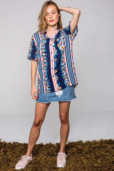 Modelo vestindo camisa estampada e saia jeans