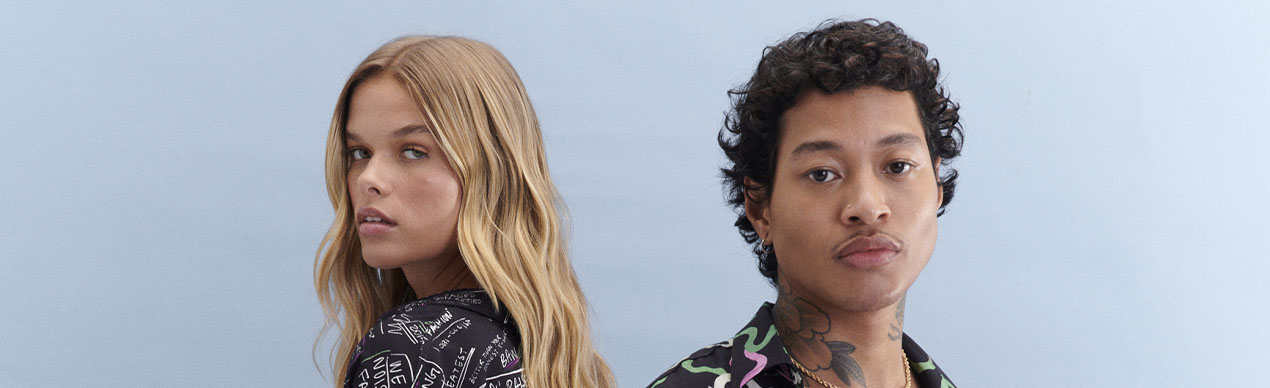 Casal com camisas estampadas em fundo claro