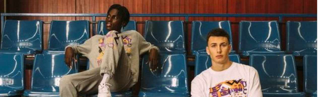 Dois jovens modelos sentados em cadeiras azuis.
