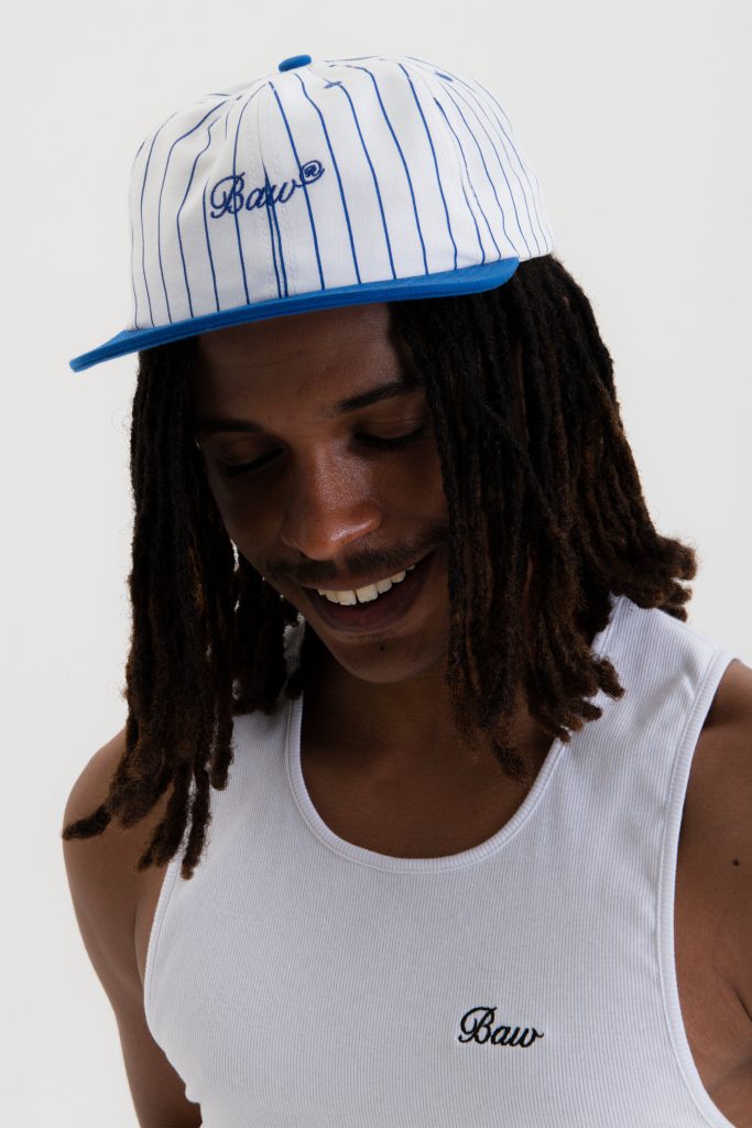 Homem sorrindo com boné listrado azul e branco