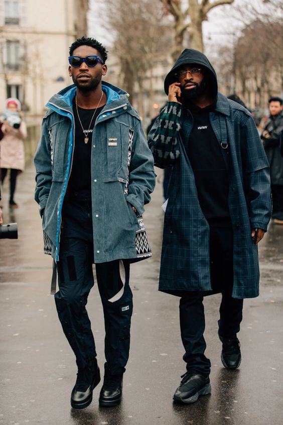 Dois homens estilosos caminhando na rua com roupas de inverno.