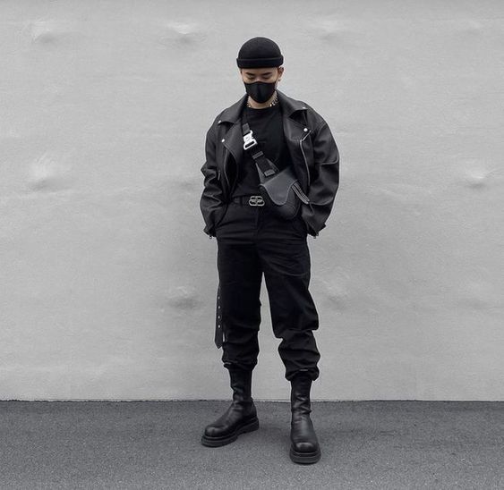 Jovem com estilo urbano, vestindo roupas pretas.