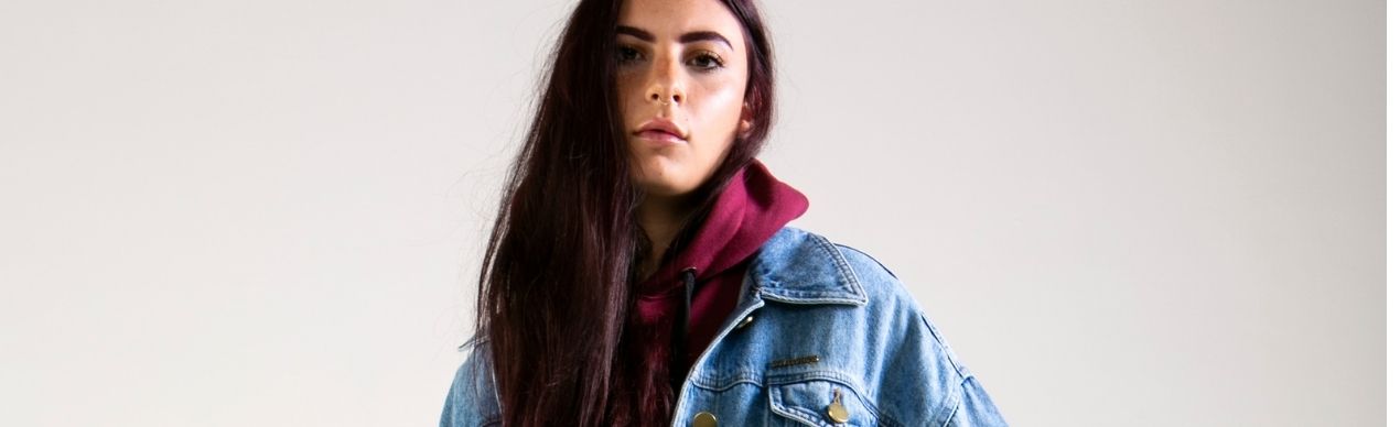Jovem com jaqueta jeans e moletom vermelho