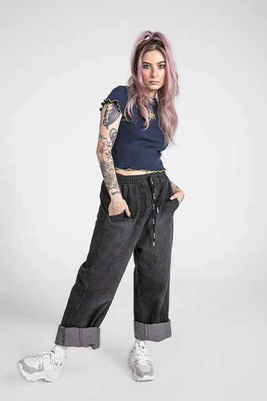 Jovem com cabelo rosa usando look casual moderno.