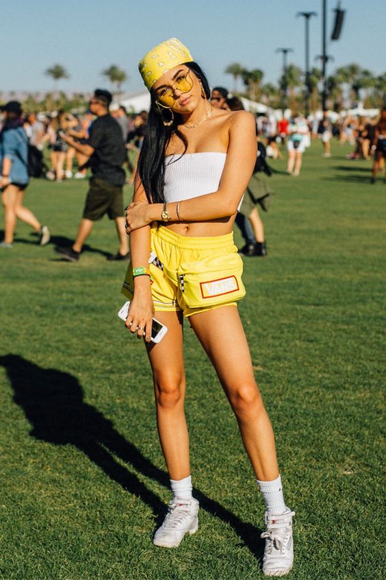 Jovem de shorts amarelos em evento ao ar livre