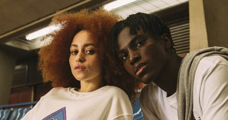 Jovens com cabelo volumoso em ambiente urbano.