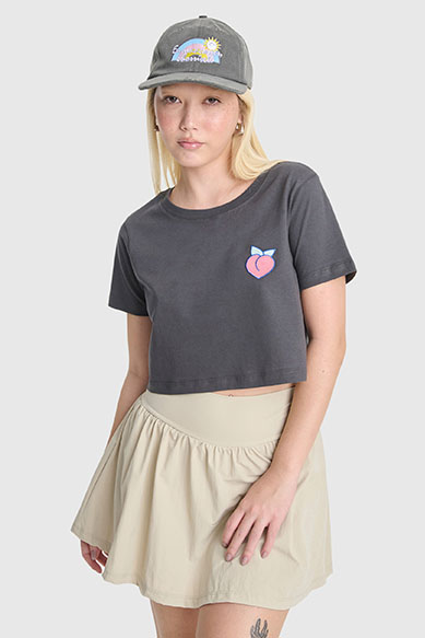 Modelo usando camiseta cropped e saia clara