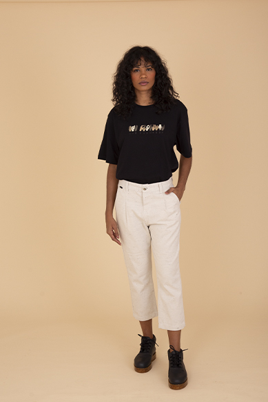 Modelo feminina usando camisa preta e calça clara