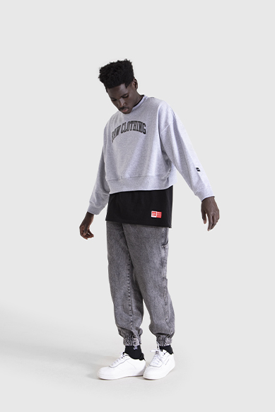 Modelo masculino com roupa casual e tênis brancos.