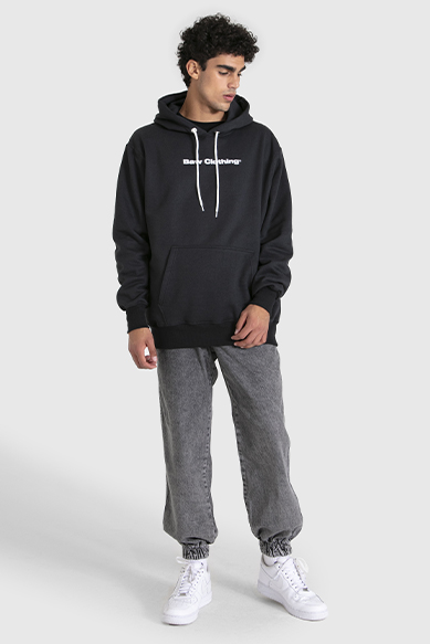 Jovem usando moletom preto e calça cinza