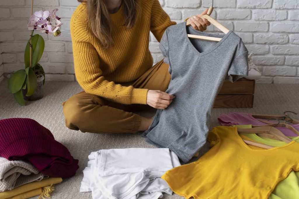 Pessoa organizando roupas em casa