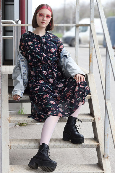 Modelo jovem com vestido floral e jaqueta denim